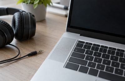 Laptop z widoczną kratką głośnika i odłączonymi słuchawkami